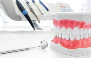 A dental machine and a dental model on a table in a dentist's office.