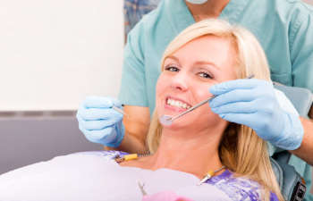A woman is getting her teeth cleaned by a dentist.
