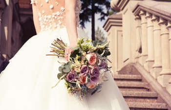 A bride in a wedding dress holding a bouquet of flowers.