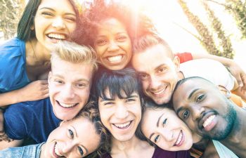 A multicultural group of smiling friends posing for a photo.