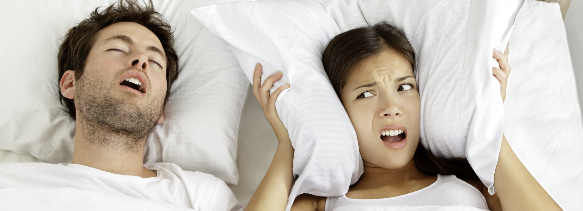 annoyed young woman who cannot sleep due to her partner's snoring