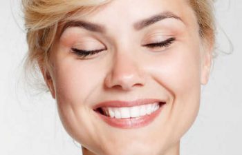 A cheerful woman smiling with her eyes closed.