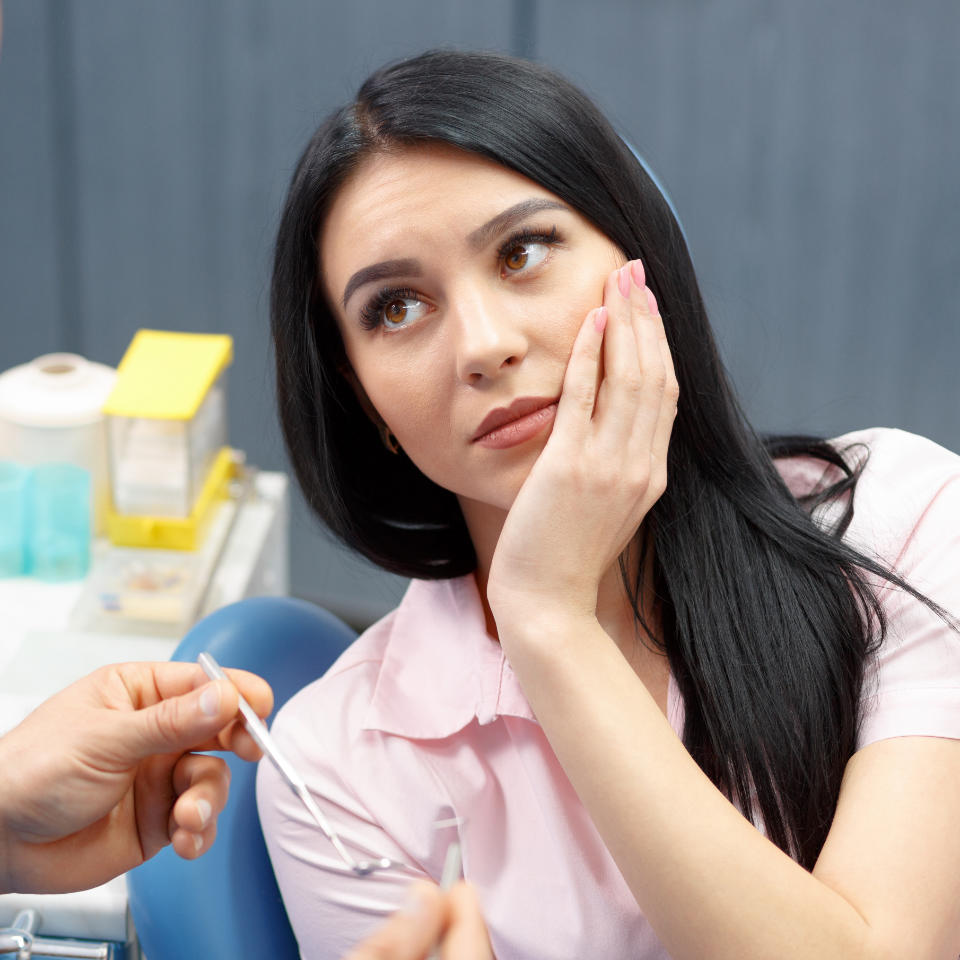 A woman with dental pain during an emergency dental appointment.