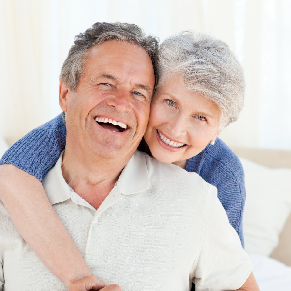 Happy senior man and a woman showing their nice teeth in their smiles.