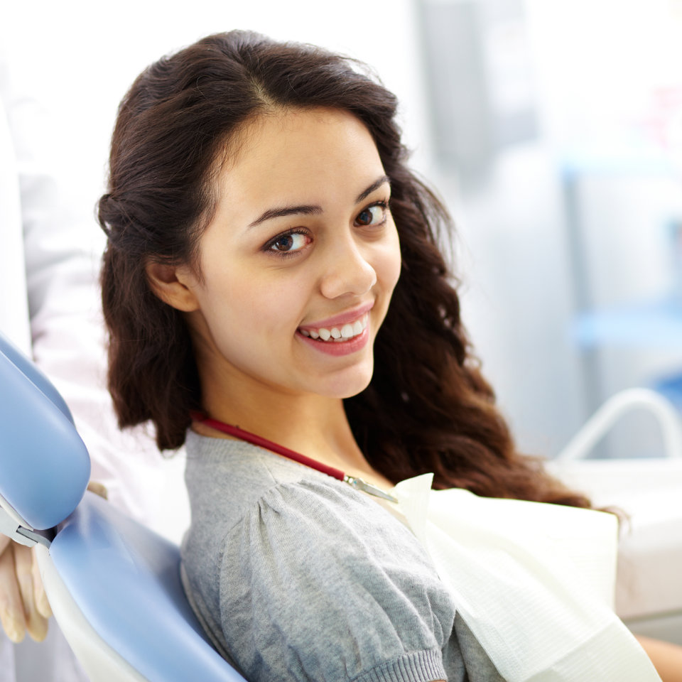 A woman sitting in a dentist's chair.