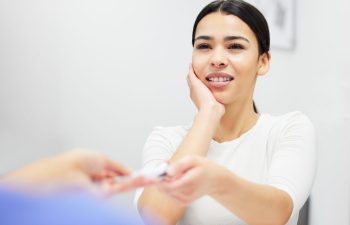 Young woman with toothache at emergency dentistry office desk